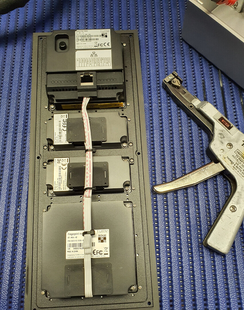 Offenes Server-Blade-Chassis mit mehreren Festplattenmodulen, Ribbon-Kabeln, daneben Crimpzange