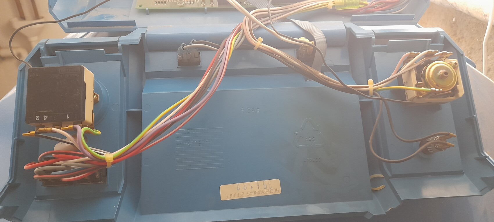 Innenseite eines blauen Elektronikgehäuses mit Kabelbäumen, Relais, Potentiometer und Platine.