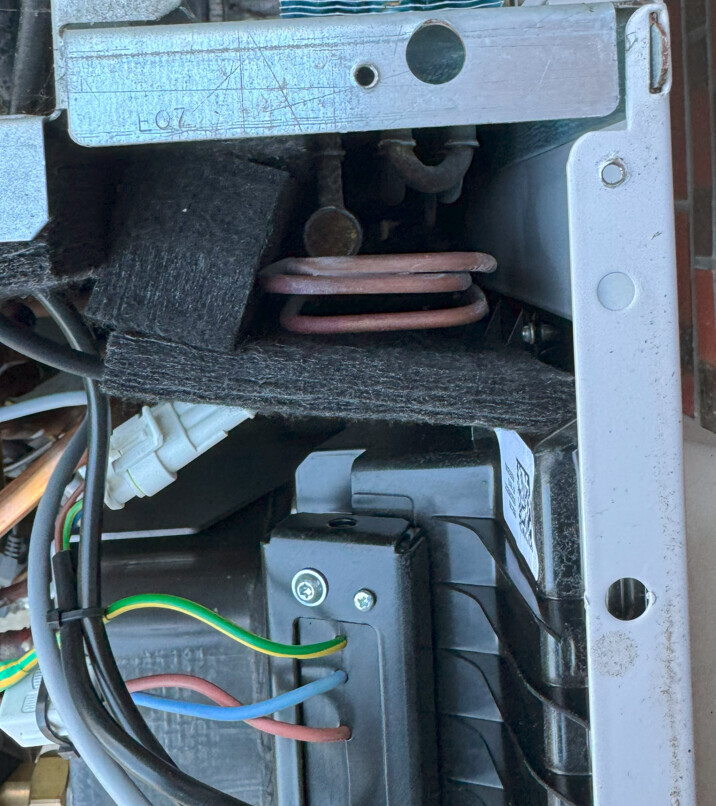 Innenraum eines Elektrogeräts mit Heizspirale, Rahmen und Kabeln.