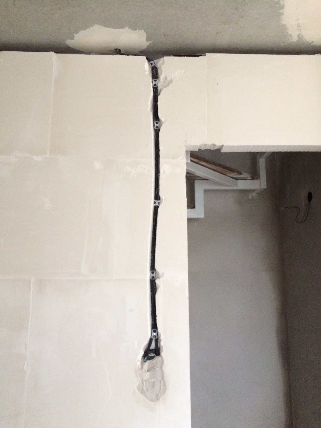 Elektrische Verkabelung sichtbar in einer Wandbaustelle, Weißflächen und Rohbau