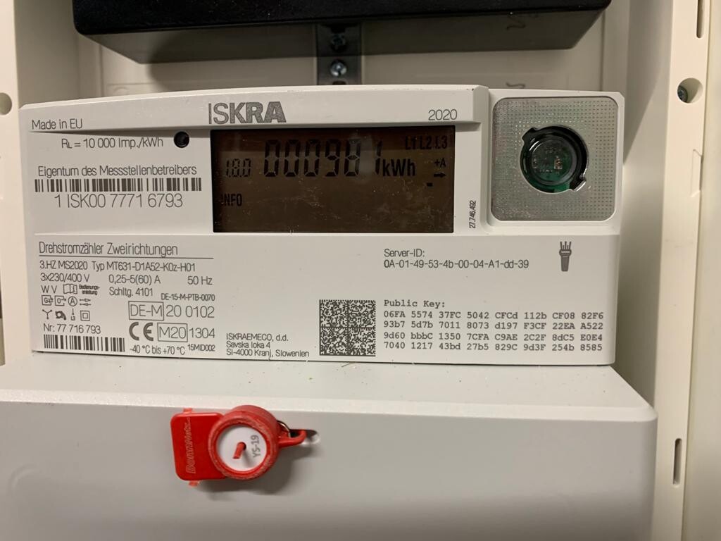 Dreiphasiger ISKRA-Stromzähler mit Digitalanzeige und rotem Sicherheits-Siegel.