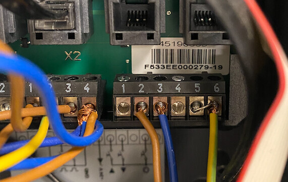 Elektronische Steuereinheit mit Schraubklemmen 1–6 und bunten Verbindungskabeln.