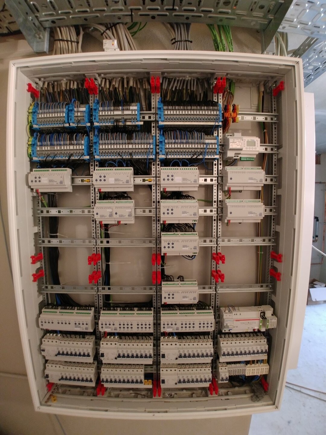 Elektrischer Schaltschrank mit umfangreicher Verdrahtung, Klemmen und Steuermodulen.