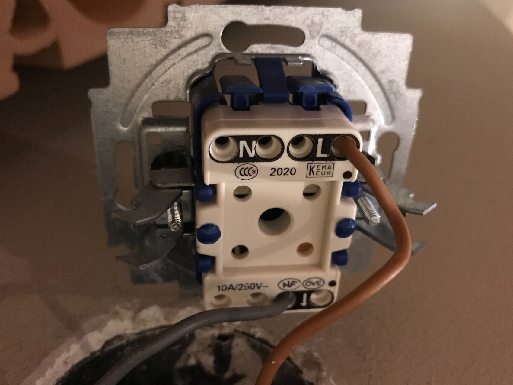 Nahaufnahme einer offenen Elektroinstallation mit Wandsteckdose und Kabeln