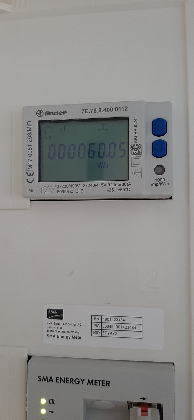 Wandmontiertes Energiemessgerät mit Display, zeigt kWh-Wert, SMA Energy Meter.