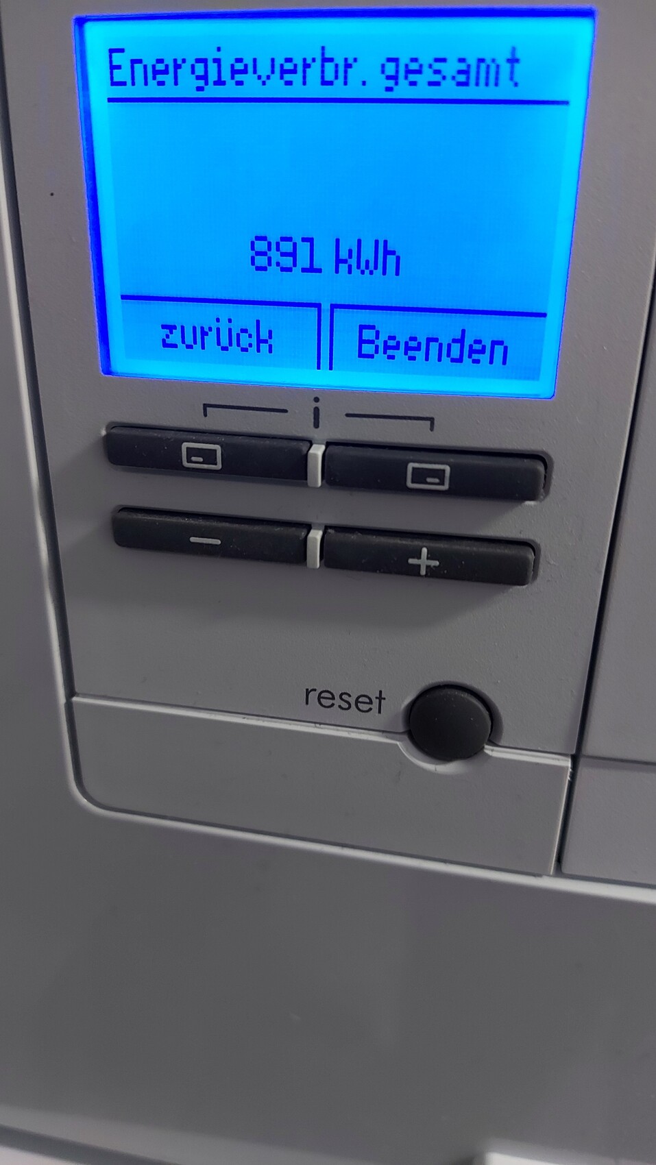 Blau beleuchtetes Energieverbrauchsdisplay zeigt 891 kWh; darunter Tasten zurück und Beenden.