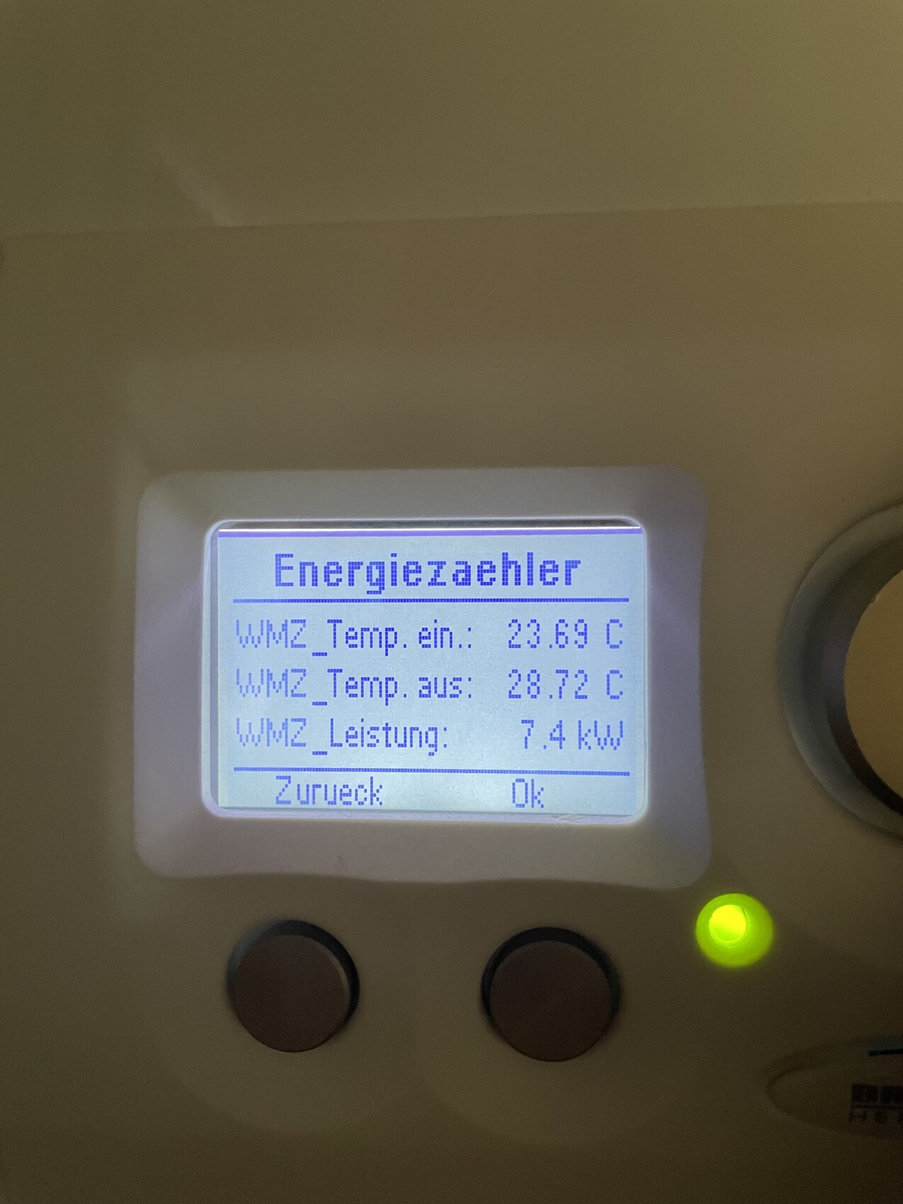Energiemeter-Display mit Temperaturen (23.69/28.72 C) und 7.4 kW.