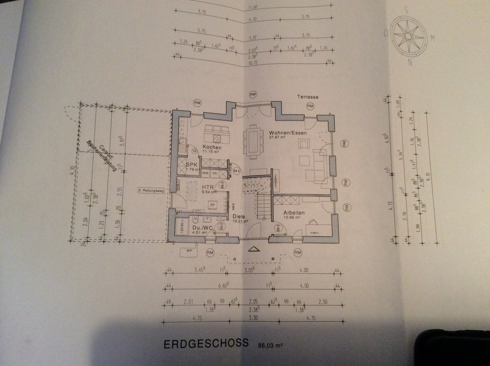 Erdgeschoss Grundriss eines Hauses mit Küche, Wohnbereich, Diele, Bad, Arbeitszimmer und Terrasse.