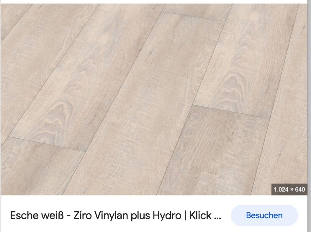 Heller Holzboden mit langen Laminat-/Vinylplanken und sichtbarer Holzmaserung.