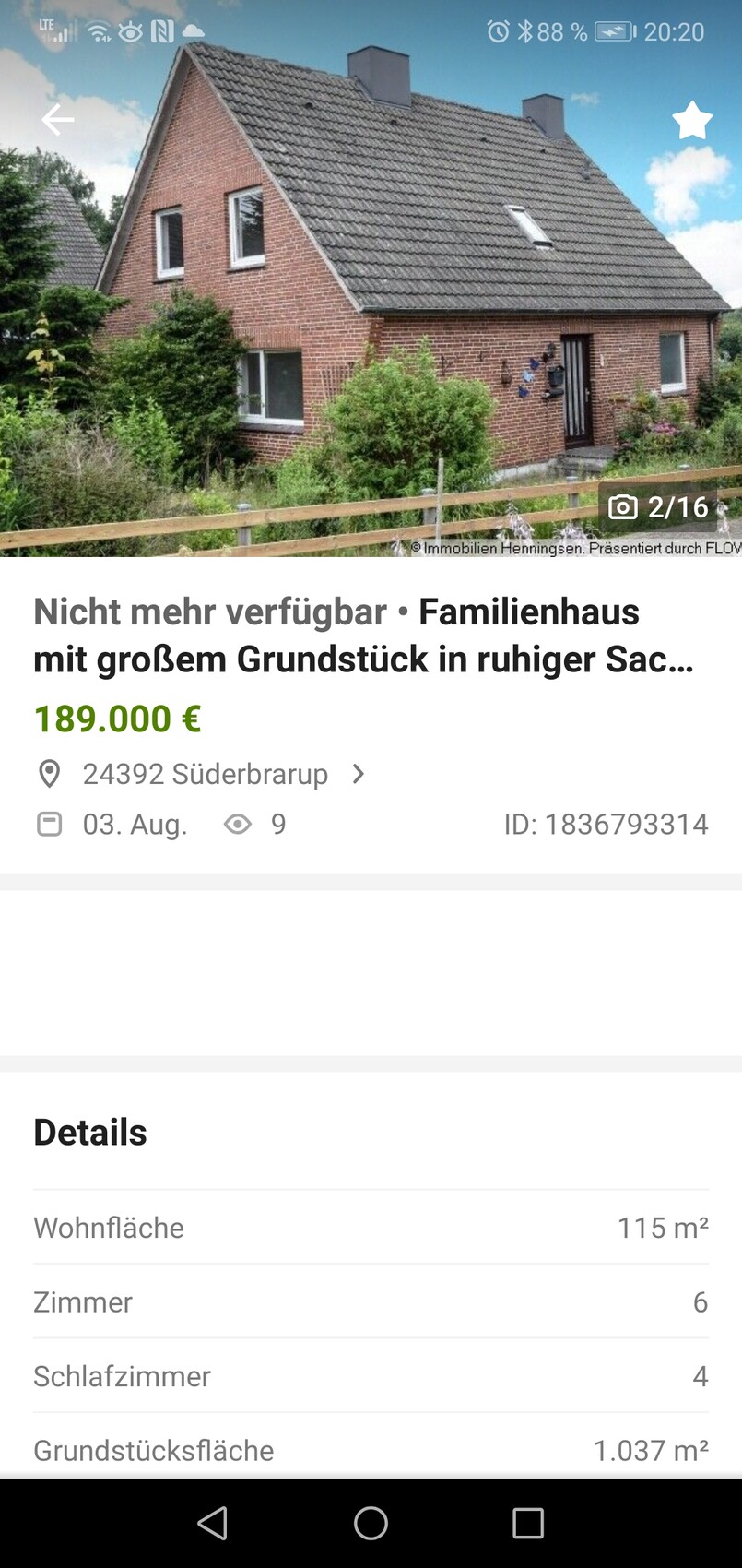 Ein rotes Backsteinhaus mit steilem Dach, Gartenanlage und Holzzaun im Vordergrund.