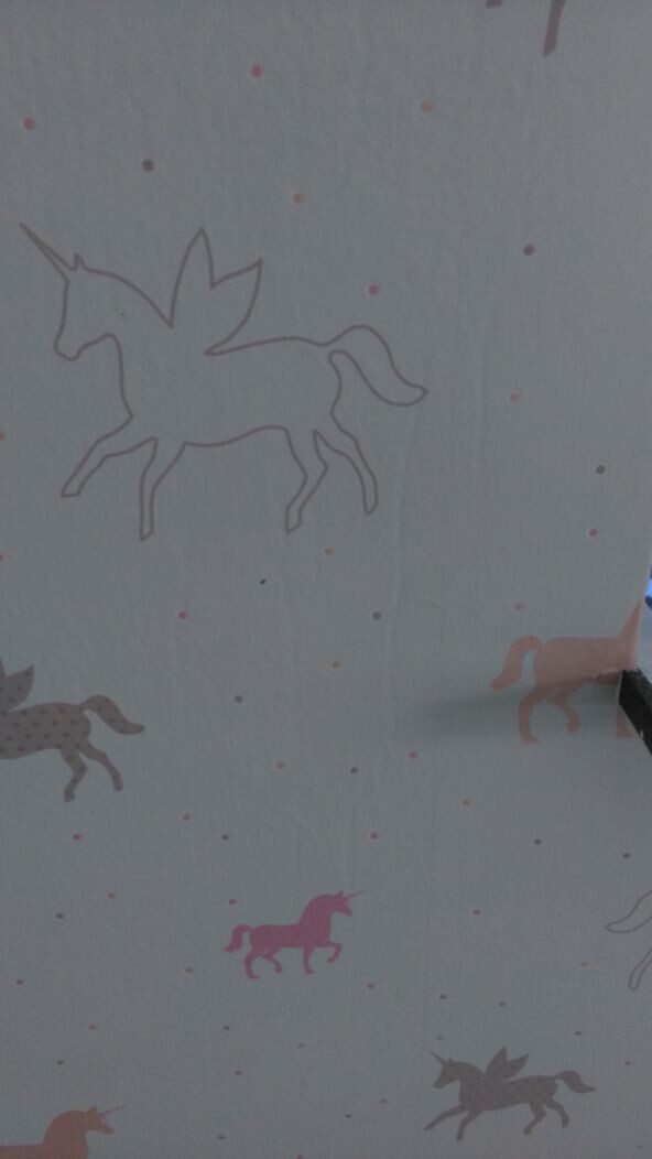 Wand mit bunten Einhorn-Motiven als Kinderzimmer-Dekoration