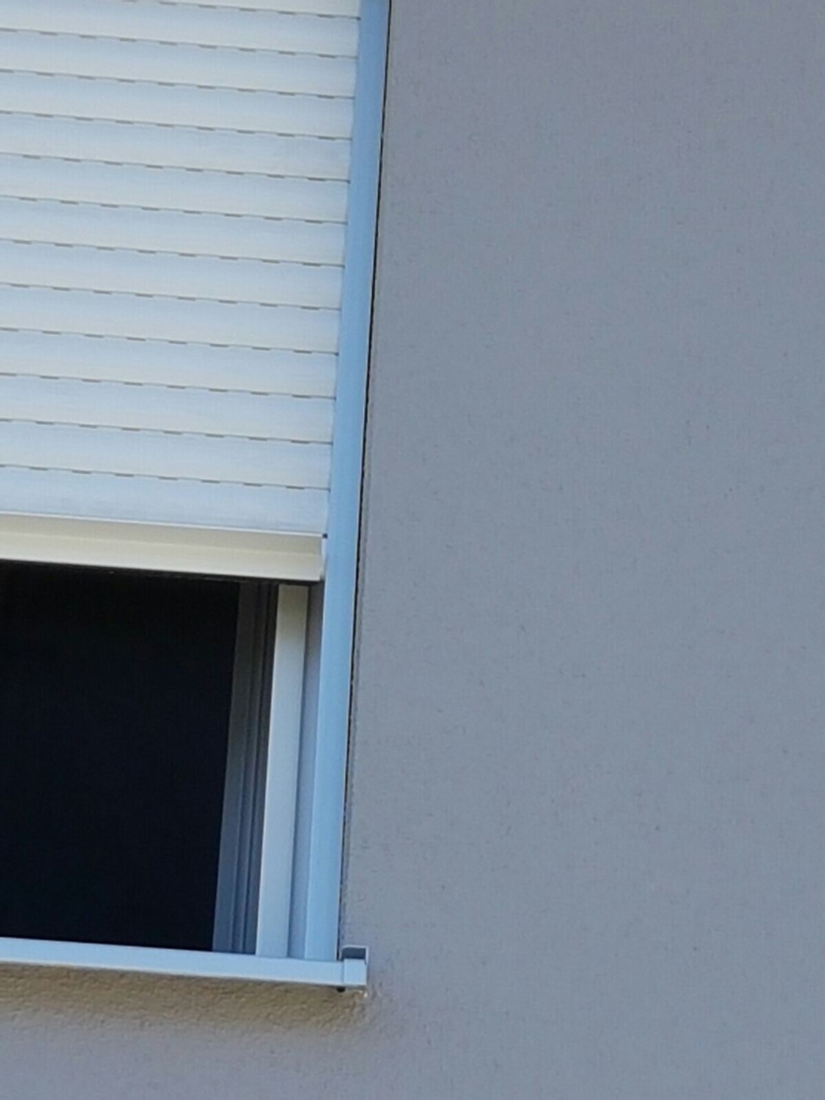Außenwand mit geöffnetem Fenster und blauem Fensterrahmen