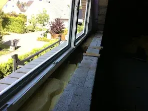 Großes offenes Fenster im Bau, Blick auf Garten und umliegende Häuser