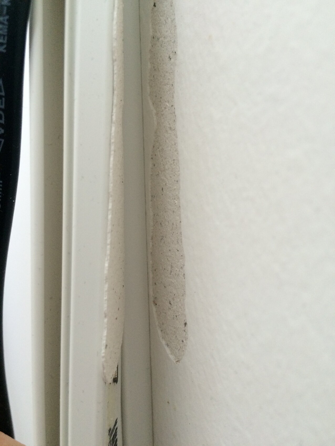 Nahaufnahme eines Fensterrahmens mit Daemmung und Dichtungsmaterial in der Wand