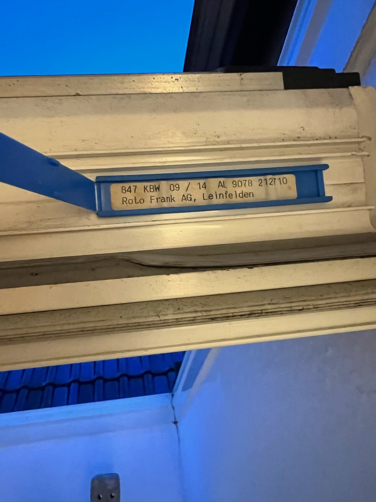 Metallschiene mit blauer Halterung; Etikett mit Roto Frank AG, Leinfelden.