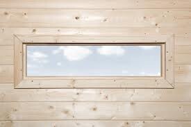 Kleines rechteckiges Fenster in heller Holzverkleidung, Blick nach draußen