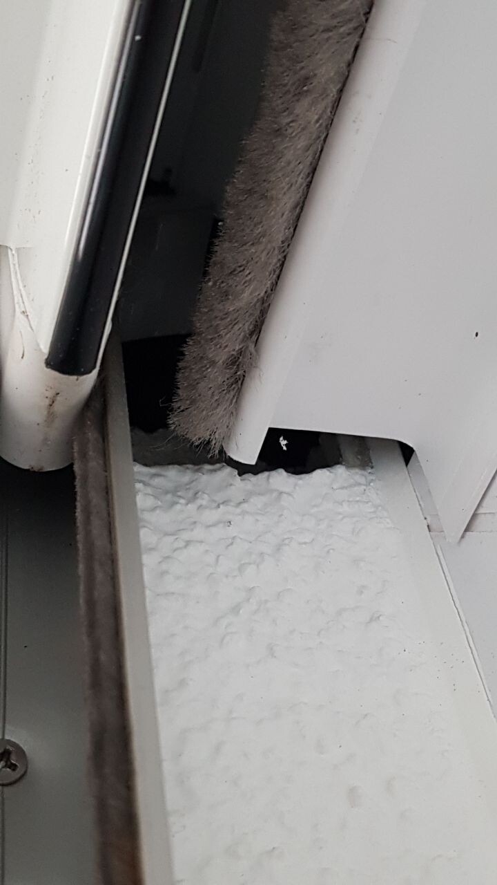 Nahaufnahme eines Fensterrahmens mit defekter Dichtung und Dämmung