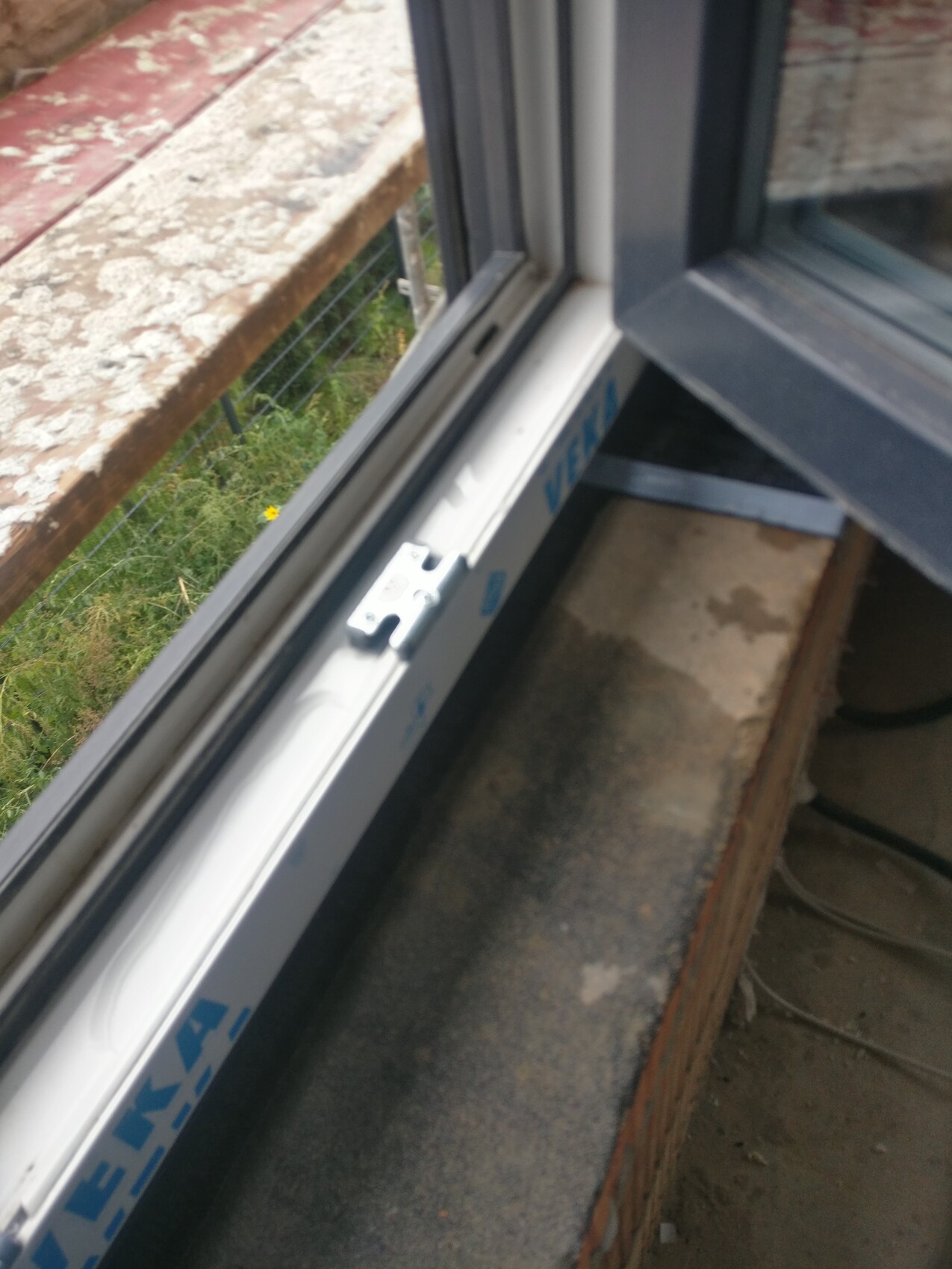 Montierter Fensterrahmen während Bauarbeiten, Außenbereich mit Zaun sichtbar