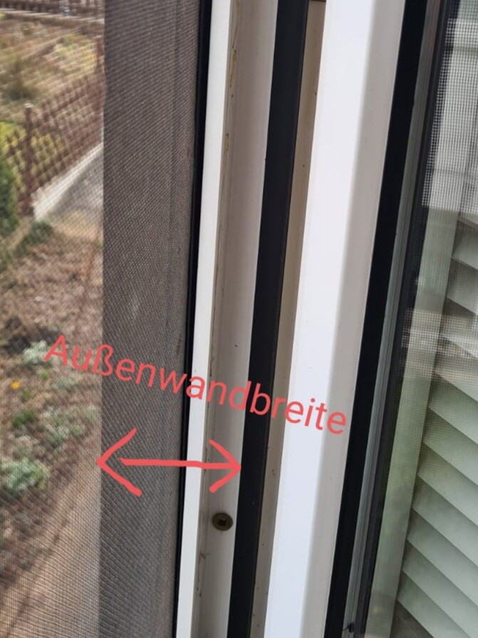 Fensterrahmen mit Insektenschutz, roter Text „Außenwandbreite“ mit Pfeilen.