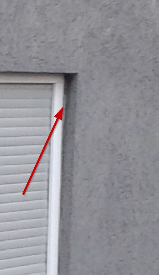 Fenster mit Rollladen in grauer Außenwand