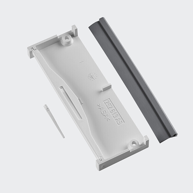 Weißes Kunststoffgehäuse mit dunkler Schiene als Fensterrollladen-Halterung