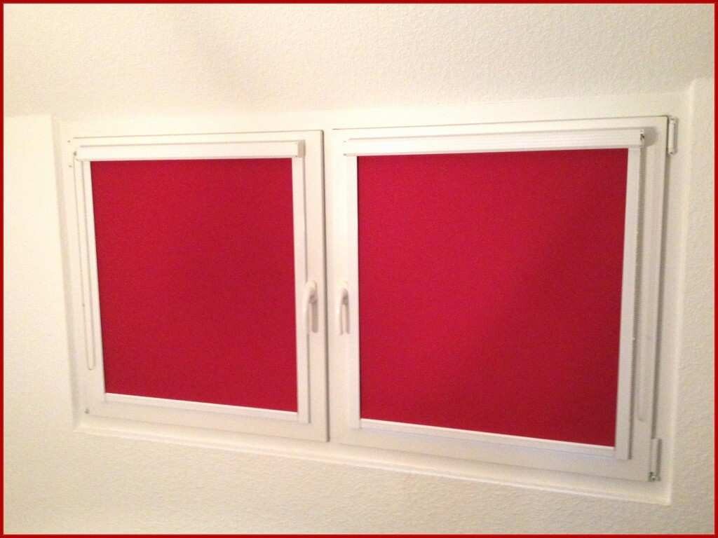 Zwei weisse Fenster mit roten Rolllaeden an weisser Wand Innenansicht