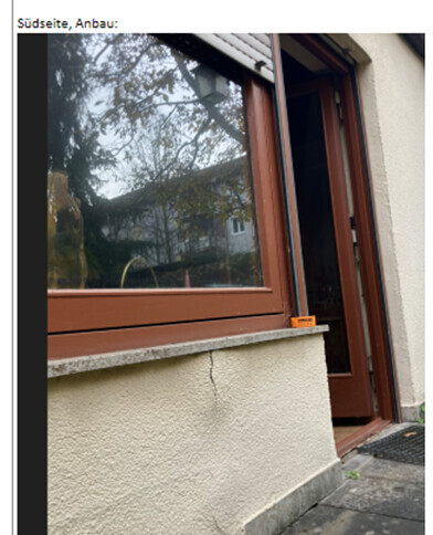 Südseite des Anbaus mit braunem Fenster, Fensterbank aus Stein, offene Tür.