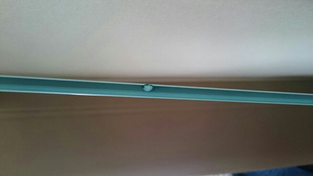 Nahaufnahme einer tür- oder fenster-schiene in blau-grün mit kleinem weißen Knopf