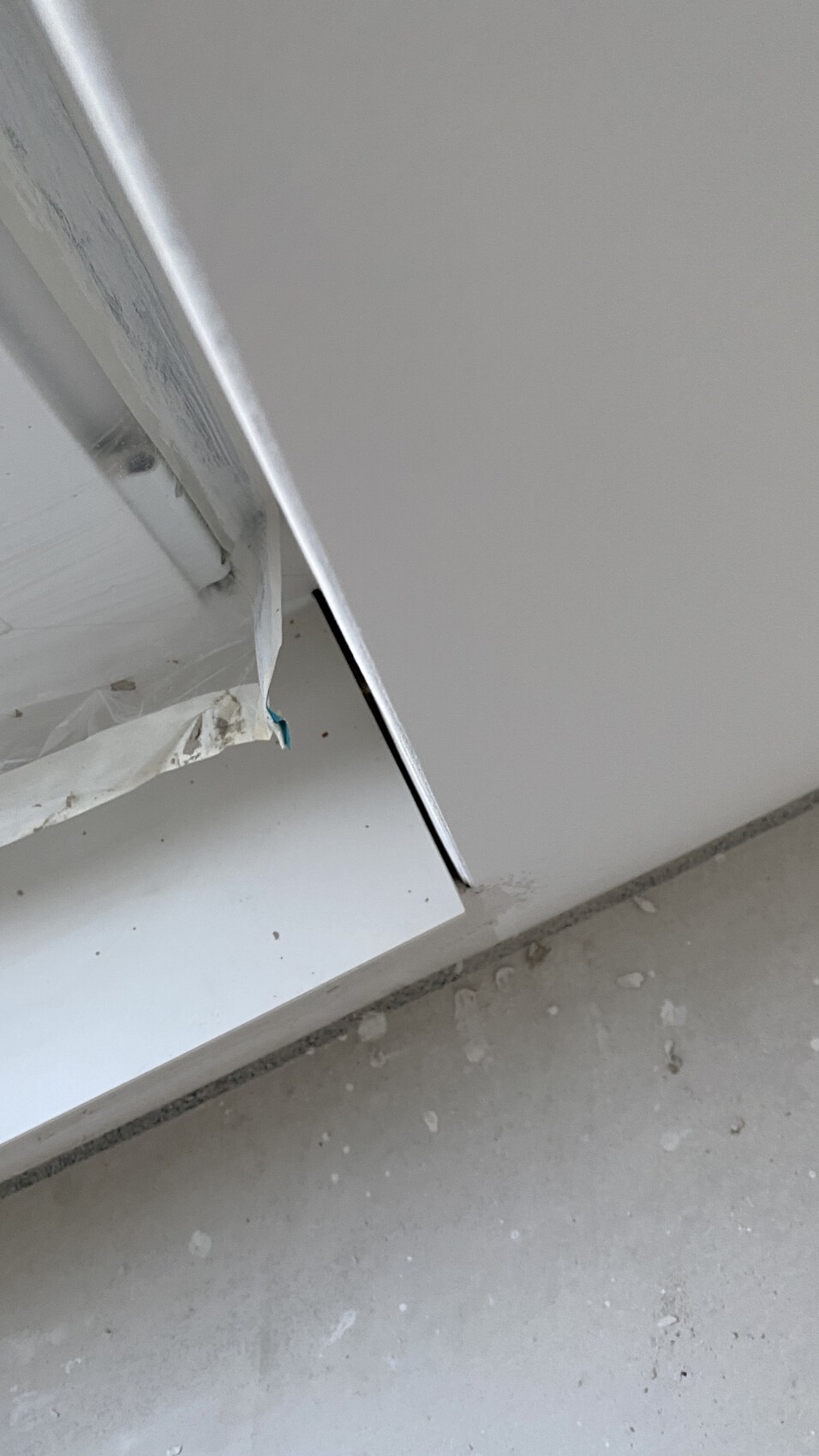 Weiss Küchenschrankfront mit Schutzfolie, schraeg abstehend, Staub am Boden