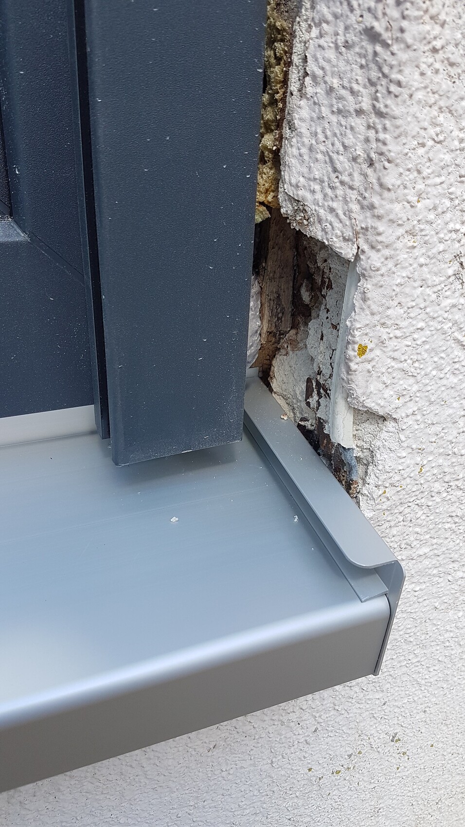 Nahaufnahme eines Fensterrahmens an einer Aussenwand mit Riss und Putzschaden