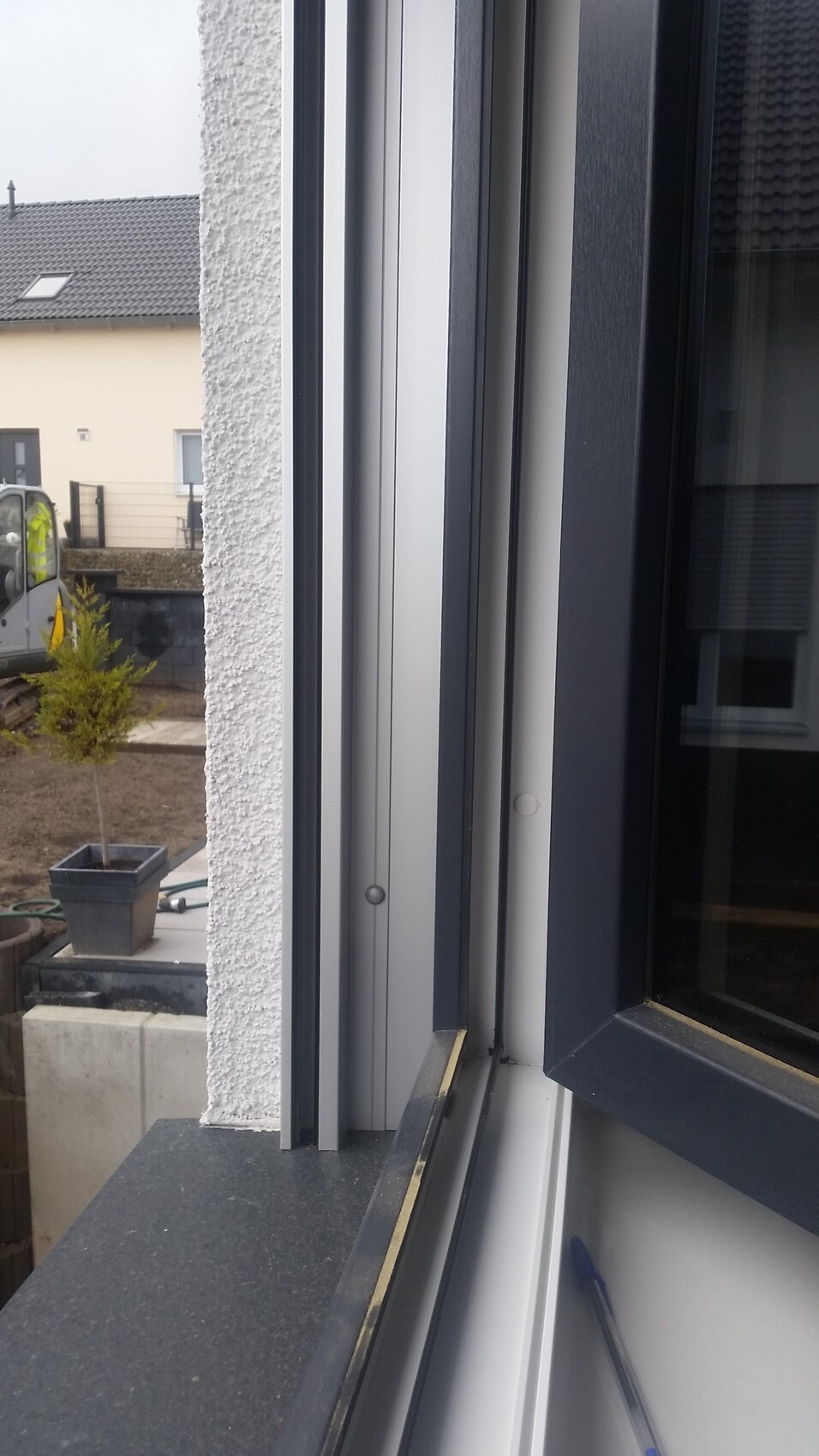 Nahaufnahme eines modernen Fensterrahmens mit Dichtungen, Baustelle im Hintergrund