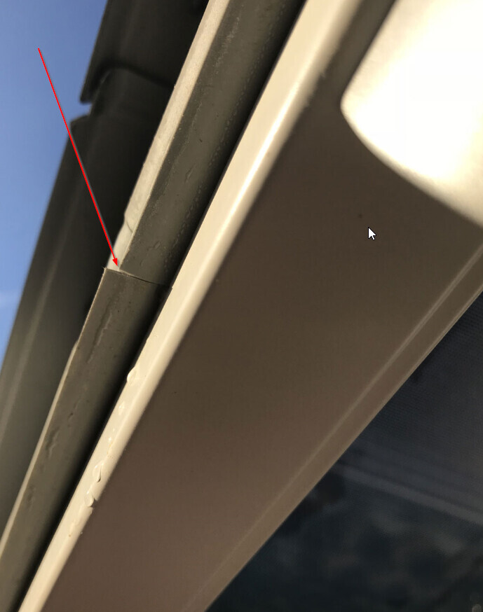 Nahaufnahme eines Fensterrahmens mit sichtbarem Spalt und Beschädigungen an der Dichtungsfuge