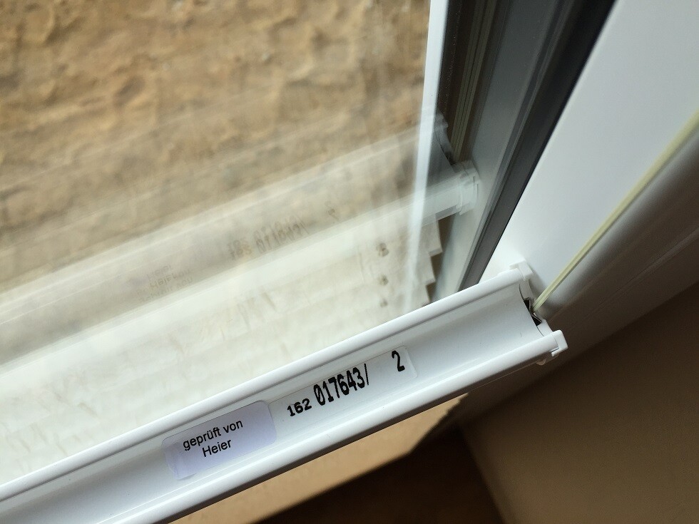 Weißer Fensterrahmen mit Dichtung, Innenansicht, Beschriftung am Flügel
