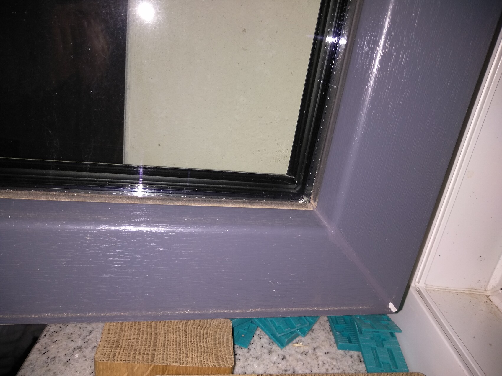 Nahaufnahme eines dunkelgrauen Fensterrahmens mit Glasfenster