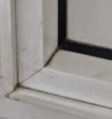 Nahaufnahme einer weißen Fensterrahmen-Ecke mit Dichtung