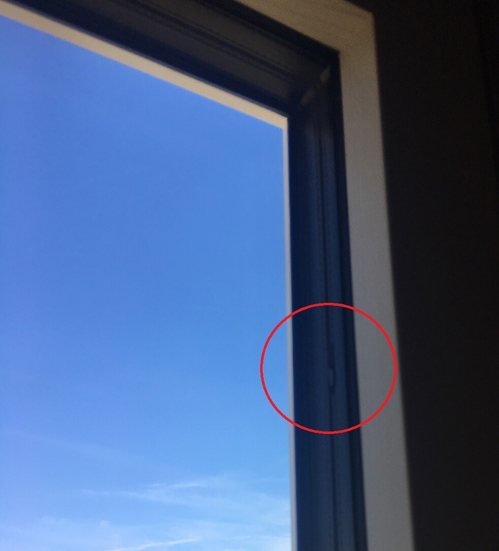 Fensterrahmen Innenansicht mit blauem Himmel, roter Kreis markiert eine Stelle am Rahmen