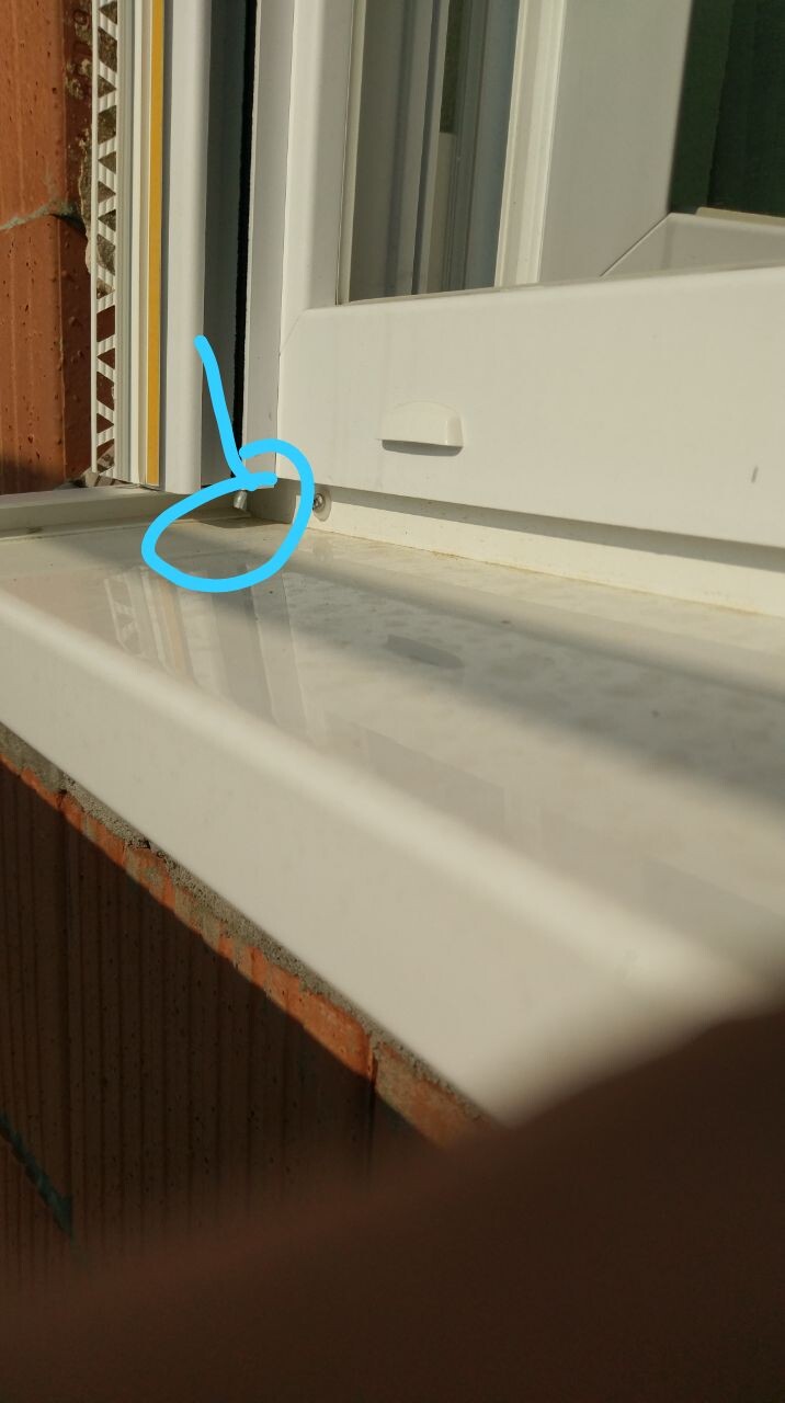 Weißer Fensterrahmen und Fensterbank mit kleinem Spalt am unteren Rand der Fensteröffnung.