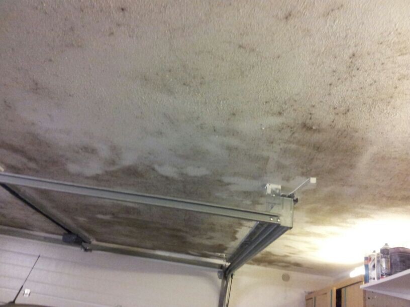 Feuchte Decke mit Wasserschäden über Garagentormechanik in Garage