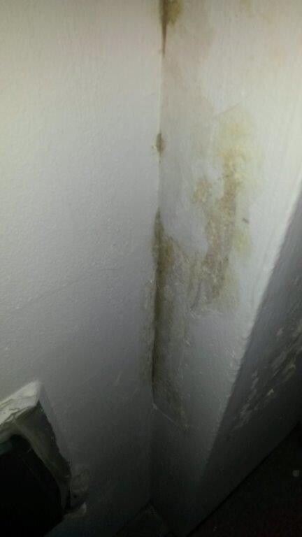Feuchte Wand-Ecke mit Schimmelbefall und Feuchtigkeitsflecken