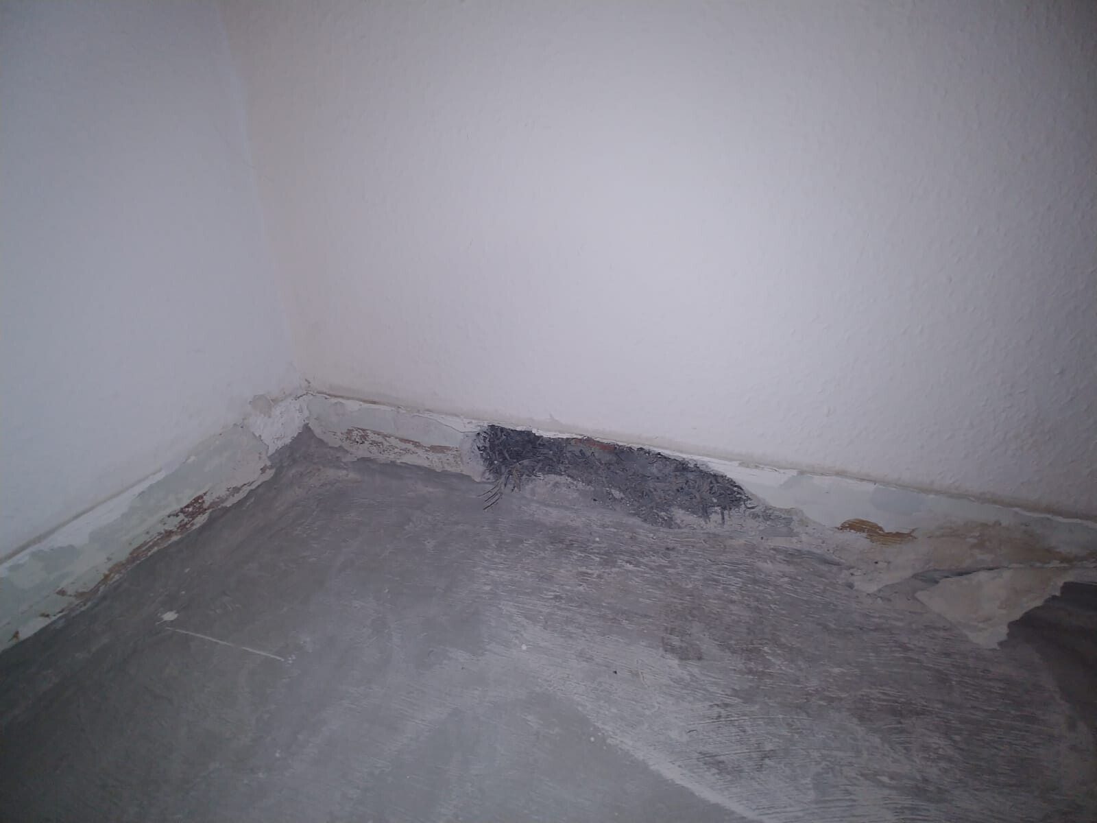 Eckbereich mit Feuchtigkeitsschaden an Wand und Bodenplatte