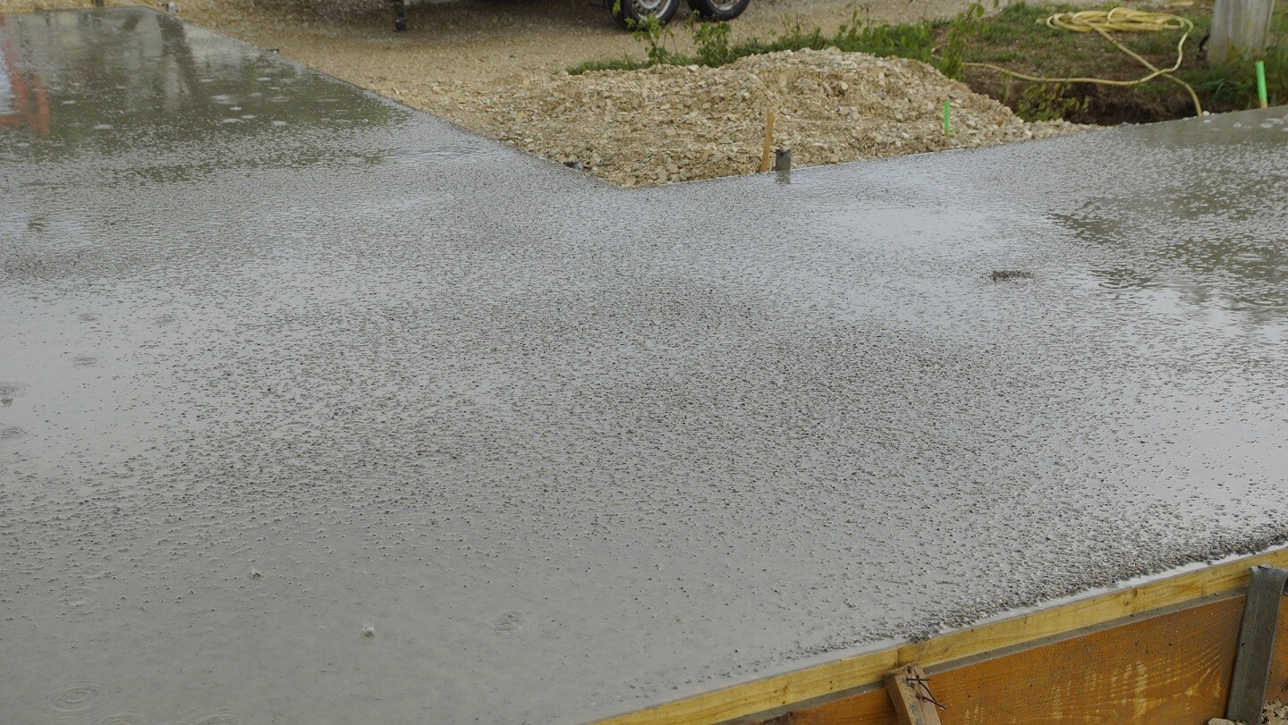 Frisch gegossenes Betonfundament mit Holzformen auf einer Baustelle