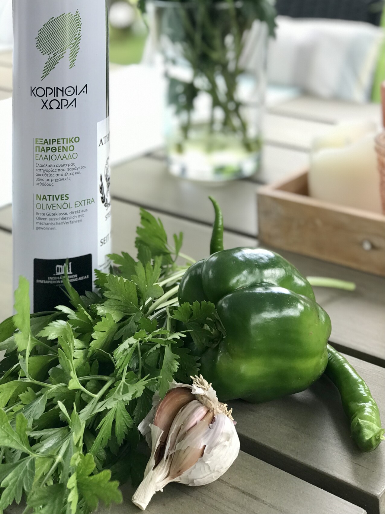 Petersilie, Knoblauch, grüne Paprika und Olivenölflasche auf Holztisch.