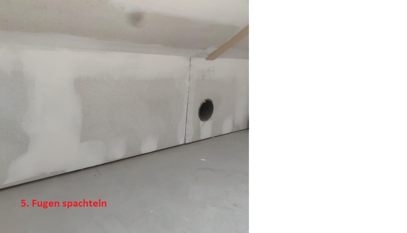 Baustelle: gespachtelte Wandfugen, rundes Loch in der Wand, Bodenplatte sichtbar.