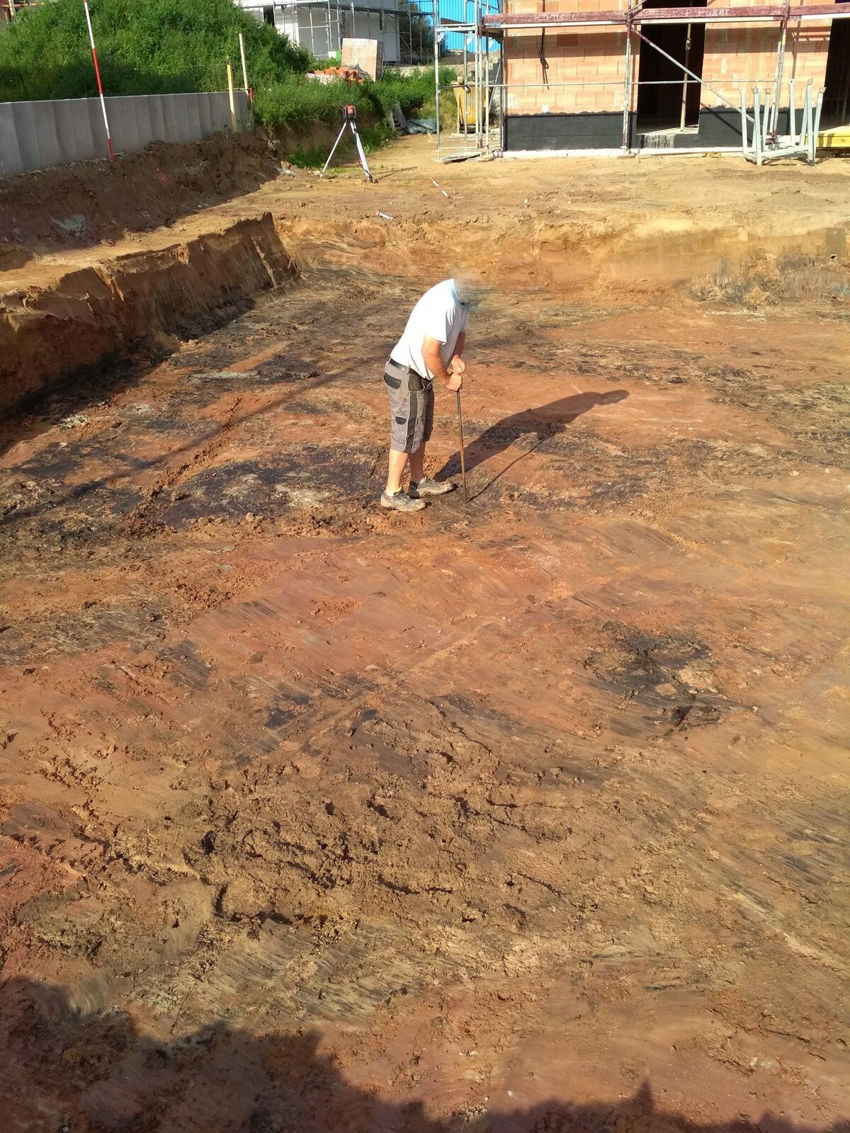 Mann arbeitet auf einer Baugrube beim Fundamentaufbau auf einer Baustelle