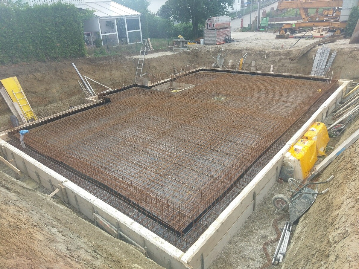 Fundamentplatte mit Bewehrungsstahl, Baugrube und Schalung sichtbar