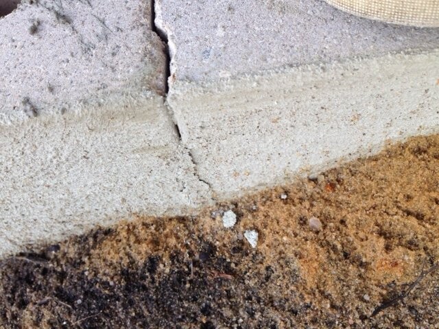 Riss im Fundament neben Betonwand mit Erdreich sichtbar, Baumangel.