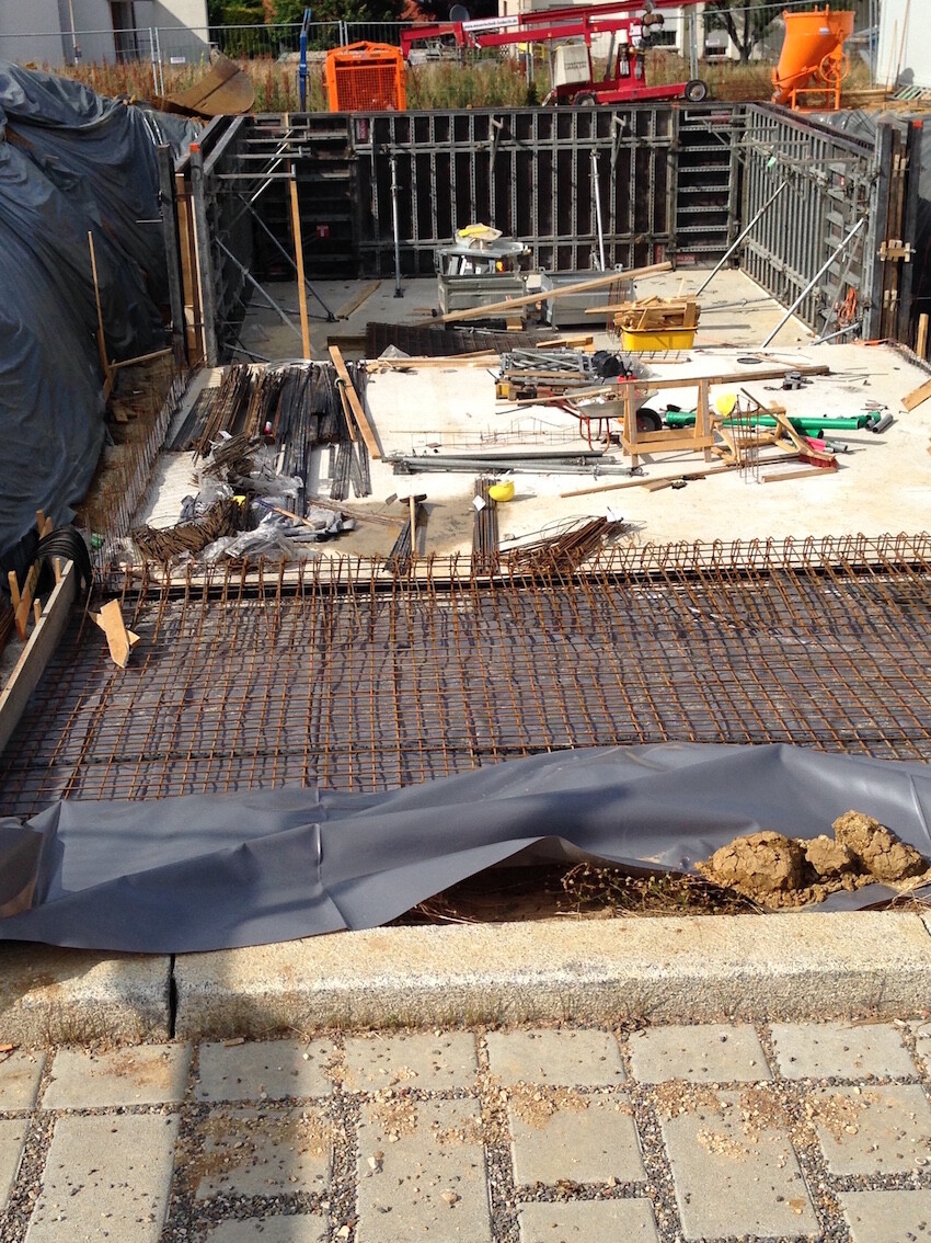 Baustelle mit Fundamentformung, Armierungsstahl, Holz- und Stahlbauteile