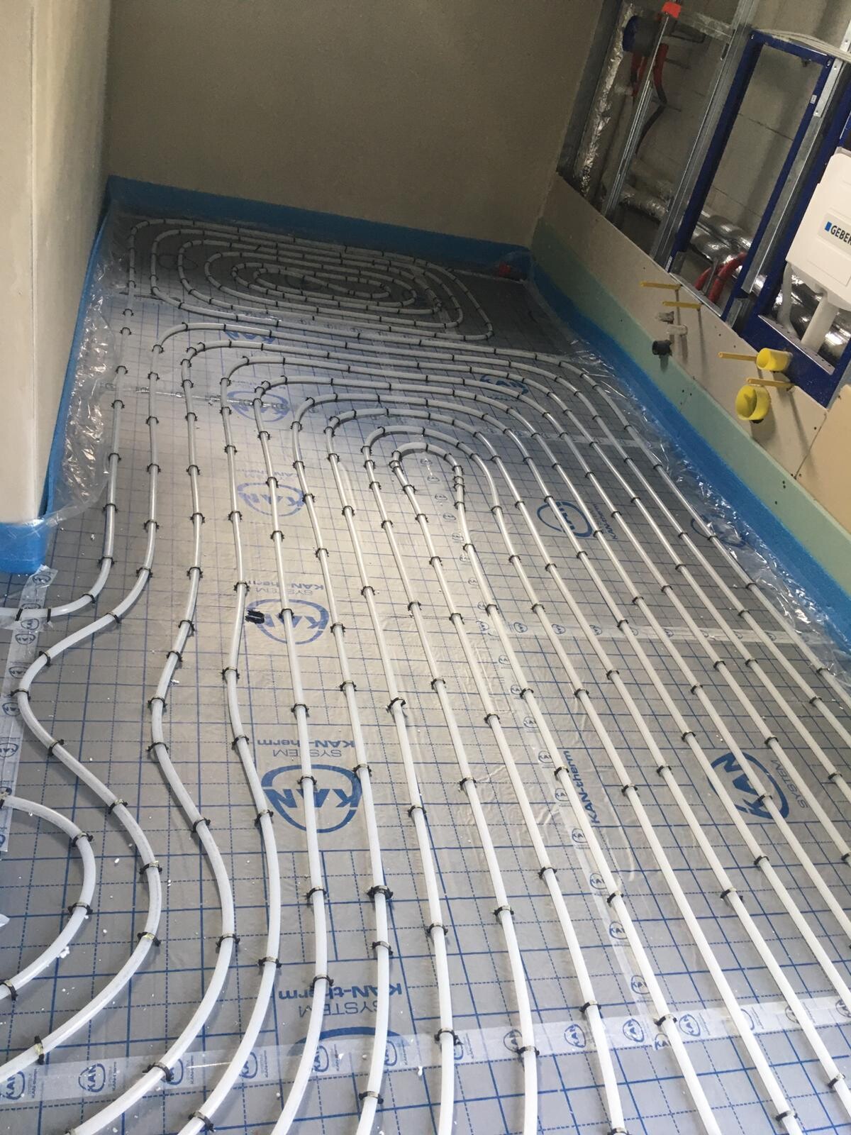 Unterflur-Heizungsrohre liegen spiralförmig auf Dämmunterlage im Installationsraum.