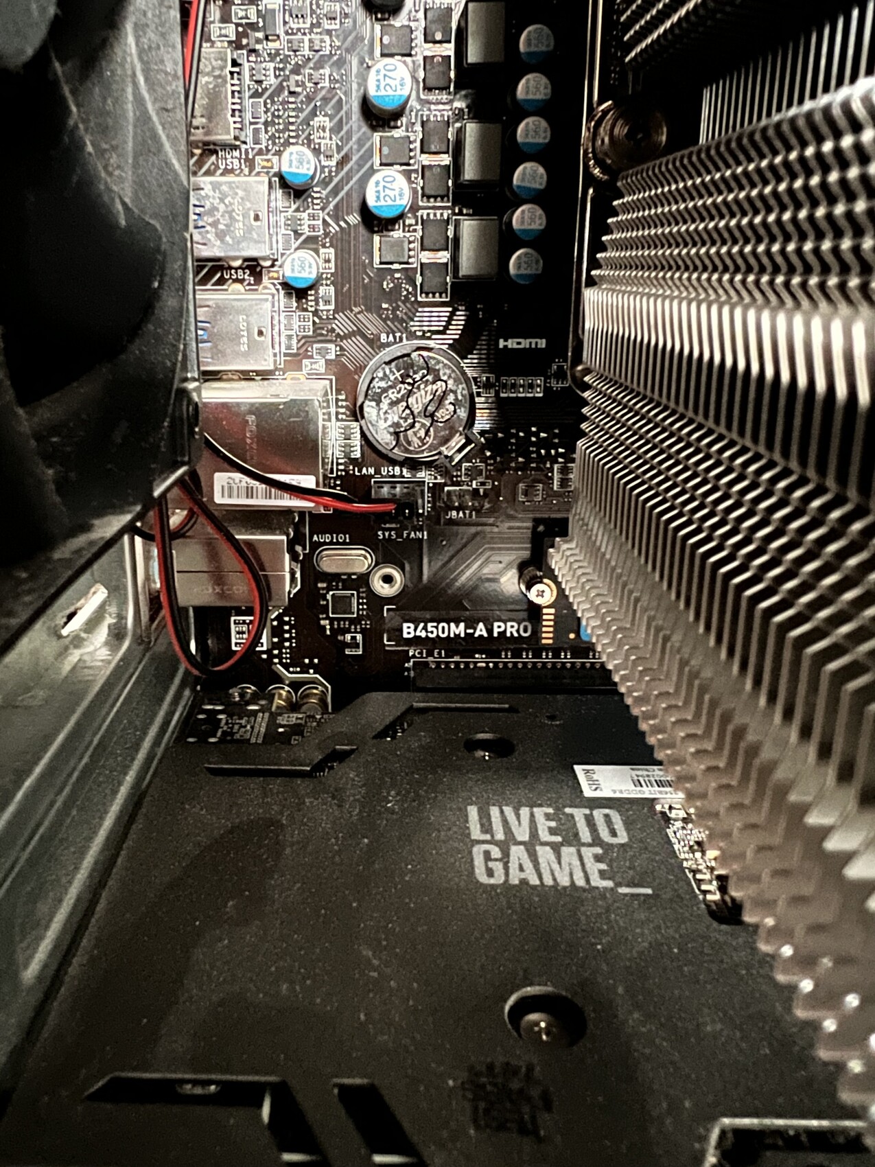 Innenansicht eines Gaming-PCs: Mainboard, Kühlkörper, Grafikkarten-Slot, Boden mit 'LIVE TO GAME'.