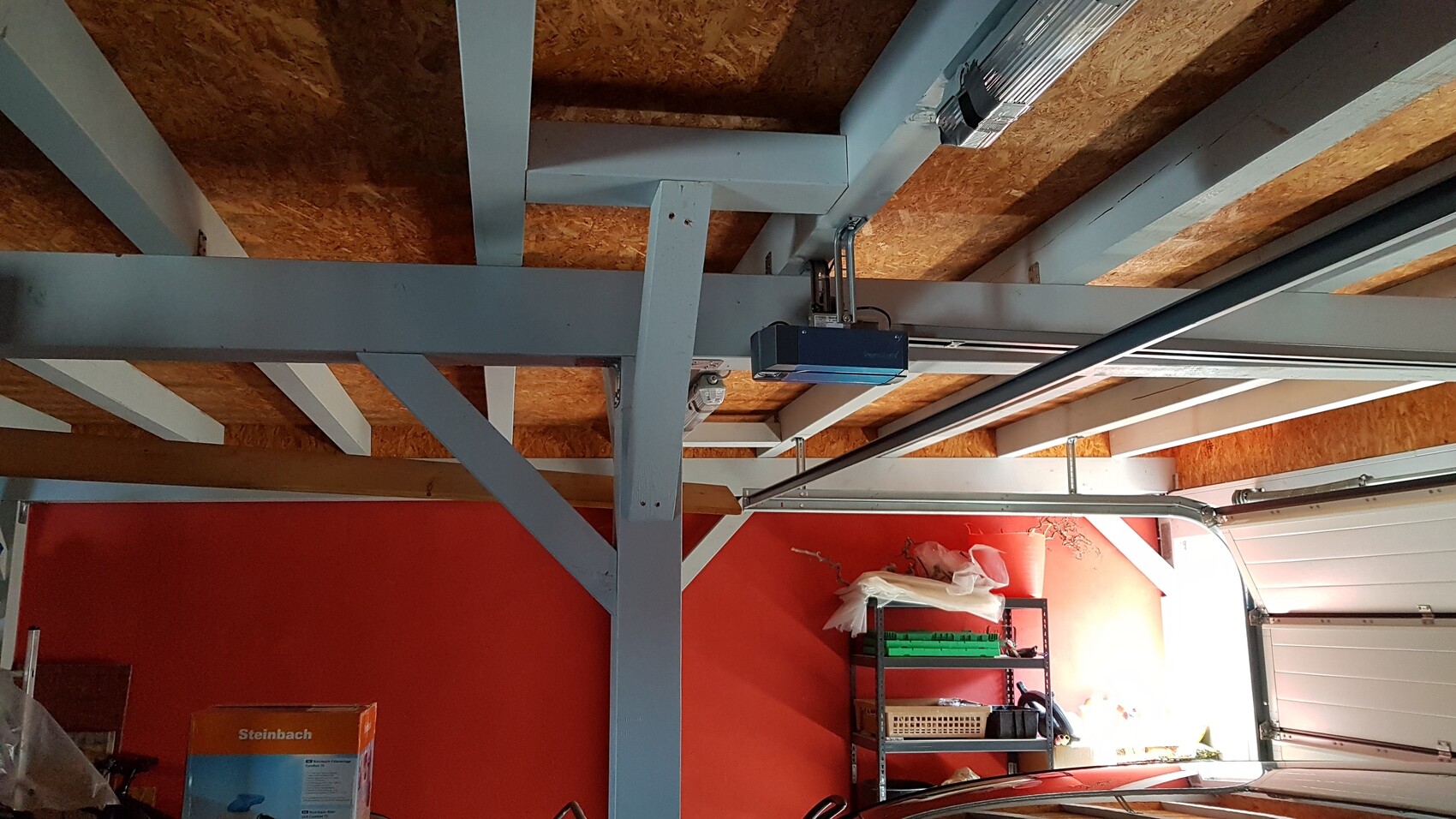 Garage mit sichtbaren Stahlträgern, Deckenbalken und Regalen im Innenraum